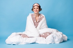 Full body photo of happy cute girl wrapped sit blanket bedroom comfort isolated on pastel blue color background