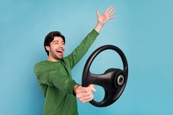 Profile side photo of young amazed crazy guy riding car fast speed extreme riding wheel isolated on blue color background