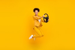 Full length body size photo woman jumping keeping steering wheel isolated vivid yellow color background