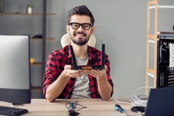 Portrait of attractive cheerful skilled trendy guy fixing repairing rout line service at office work place station indoor