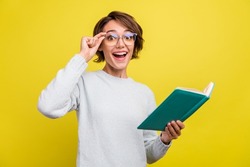 Photo of excited funny nerd lady read book open mouth wear eyewear blue pullover isolated yellow color background
