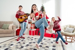 Photo of funny cool big family wear christmas sweaters dancing showing hard rock signs smiling indoors room home house