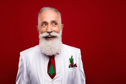 Photo of mature old happy bearded positive man look empty space good mood christmas isolated on red color background
