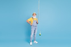 Full length photo of aged man fisherman hold spinning rod sailor isolated over blue color background