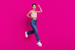 Full size photo of cheerful active young woman jump up winner celebrate isolated on magenta color background