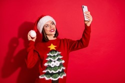 Photo of pretty shiny young woman wear ornament sweater tacking selfie modern device christmas invitations isolated red color background