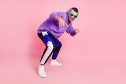 Full length photo of funky young brunet guy dance wear eyewear hoodie pants shoes isolated on pink background