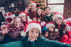Self-portrait of attractive cheerful family waving hello greetings having fun eve advent party time at home indoors