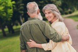 Back side photo of nice old couple wear shirt walk in park outside outdoors