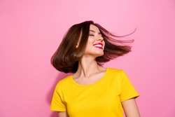Portrait of attractive dreamy cheerful girl throwing hair having fun isolated over pink pastel color background