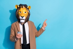Photo of freak creative guy lion mask use device point finger empty space theme event notification isolated over blue color background