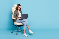 Full body photo of manager ceo lady sit chair use device netbook online communicate wear jeans isolated over blue color background