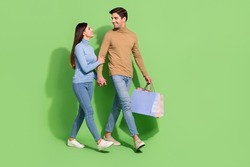 Photo of lovely shopaholic couple carry bargains enjoy store retail wear casual outfit isolated green color background
