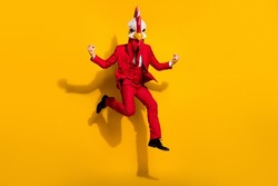 Photo of astonished office worker jump rejoice vacation wear chicken polygonal mask red tux isolated yellow color background