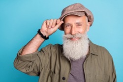 Photo of friendly grey beard aged man buy cap in old stuff wear khaki shirt isolated on blue color background