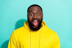 Photo of brunette funky millennial beard guy tongue out wear yellow sports cloth isolated on turquoise color background