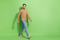 Full size profile photo of satisfied glad person walking toothy smile isolated on green color background
