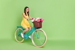 Full body profile portrait of gorgeous cheerful person riding bike look empty space isolated on green color background