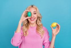Portrait of attractive cheerful wavy-haired girl holding eggs having fun isolated over bright blue color background