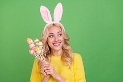 Photo of nice young blond lady hold eggs look promo wear ears yellow pullover isolated on green color background