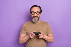 Portrait of funny ecstatic good mood man playing playstation addicted to videogames isolated on violet color background