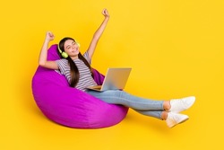 Profile side photo of young girl have fun listen music headphones melody sit soft purple chair isolated over yellow color background
