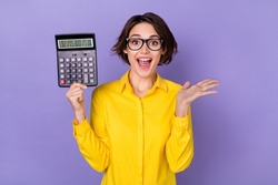 Photo of ceo young brunette lady hold calculator yell wear spectacles yellow shirt isolated on purple color background