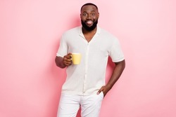 Photo of pretty charming guy dressed white shirt smiling enjoying tasty coffee isolated pink color background