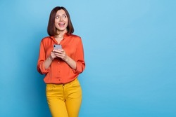Portrait of attractive cheerful curious girl using device copy space media news like isolated over bright blue color background