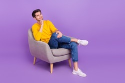 Full body image of young positive dreaming man sit armchair relaxing brainstorming isolated on purple color background
