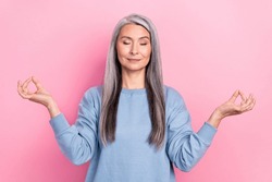 Photo of pretty dreamy retired woman blue sweater smiling enjoying yoga isolated pink color background