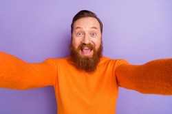 Photo of laughing foxy man blogger take selfie making video from his trip isolated on violet color background