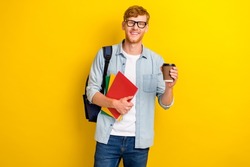 Portrait photo of young attractive guy wear glasses hold cup coffee break nerd studying isolated on yellow color background