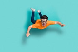 Full body size photo of young funny excited positive guy wear glasses jump air trampoline skydiver freefall isolated on aquamarine color background