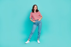 Full length photo of cheerful nice cute lady arm hand pocket dressed striped clothes denim white shoes isolated on cyan color background