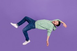 Full length photo of nice young man frighten falling down fast shouting dressed stylish khaki clothes isolated on purple color background