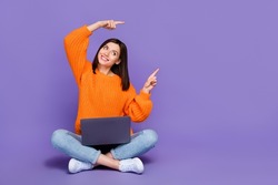 Full body photo of nice young girl netbook look direct empty space wear trendy orange knitwear garment isolated on violet color background