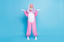 Full size photo of uncertain elderly pensioner wear pink bunny costume shrugging shoulders have no idea isolated on blue color background