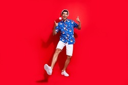 Full body photo of handsome young guy showing double thumb up wear santa claus print x-mas outfit isolated on red color background