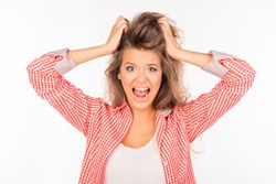Portrait of crazy young woman shouting and holding hair