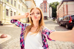 Selfie of funny attractive girl pouting and showing v-sign