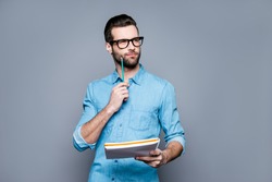 Young thoughtful bearded man in glasses thinking about test.