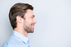 Close up side portrait of young, bearded, happy, smiling manager standing over grey background with copy space