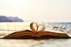 Heart shape paper book on the beach.valentine's day concept. symbol of love