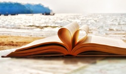 Heart shape paper book on the beach.valentine's day concept. symbol of love