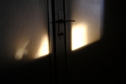Sunshine on the wooden door and white wall.