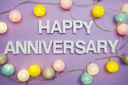 Happy Anniversary alphabet letters with LED Cotton ball Decoration on purple background