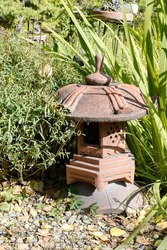 Traditional asiatic stone lantern in green garden. 