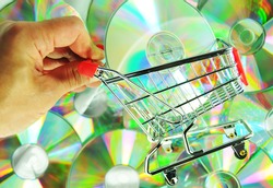  Music shopping concept with hand holding a shopping cart and music CDs or DVDs