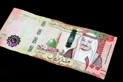 Saudi Arabia 100 riyals banknote, Saudi kingdom one hundred riyals  with the photo of king Salman Bin Abdulaziz and the green dome with The Prophet's Madinah mosque isolated on black background
